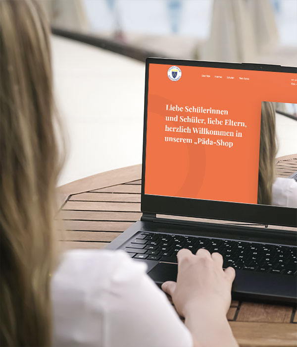 Frau sitzt vor Laptop